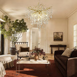 Brass-finish deep crystal branch cascade chandelier in a furnished room