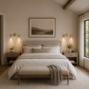 Brass twin-cylinder picture light in a bedroom