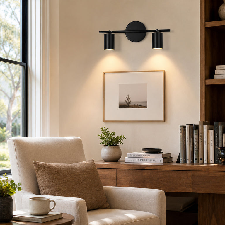 Matte-black twin-cylinder picture light above framed artwork