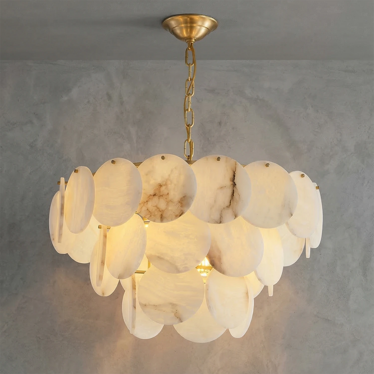 Alabaster disc chandelier with overlapping stone shades illuminated against a gray wall