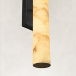 Illuminated alabaster panel and black wall-sconce backplate.
