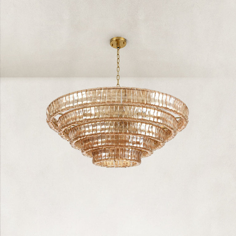 Angled view of an amber tiered glass chandelier.
