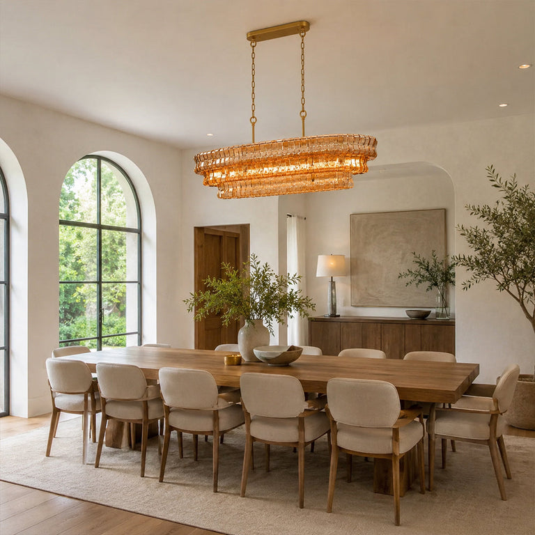 Amber glass rectangular chandelier above a table by an arched window.