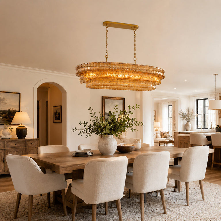 Amber glass rectangular chandelier above a dining table beside an open kitchen.