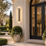 Black linear sconce beside arched doorway