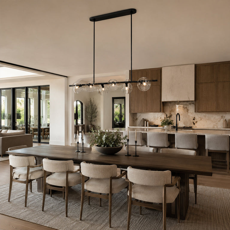 Black bubble glass linear chandelier above a dining table in an interior setting