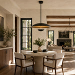 Black disc pendant above a dining table near a living room