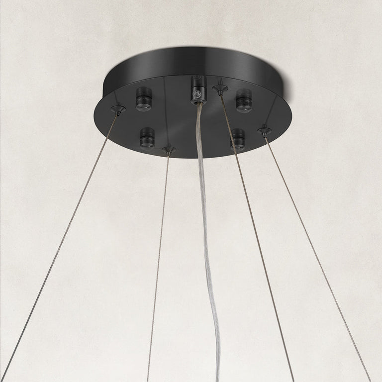Black canopy and suspension cables of a layered ring chandelier.