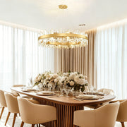 Brushed-brass crystal ring chandelier with ceiling canopy above a dining table