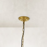 Candle ring chandelier, gold-tone ceiling canopy and chain close view.