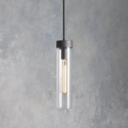 Illuminated single glass cylinder pendant with a black cap and rod.