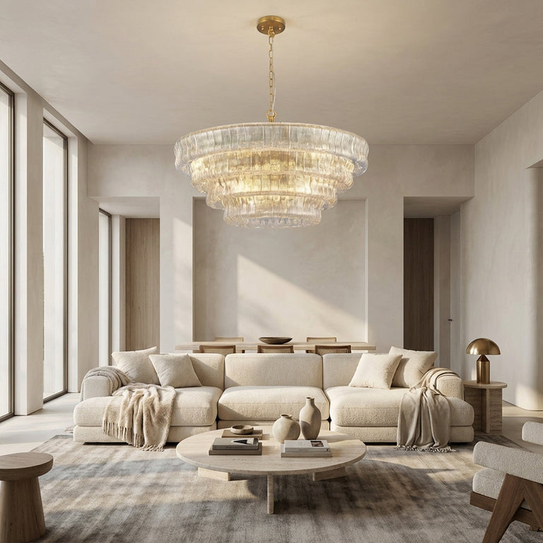 Clear round chandelier above a cream sofa and round coffee table.