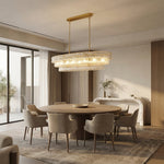 Clear glass rectangular chandelier above a round dining table.