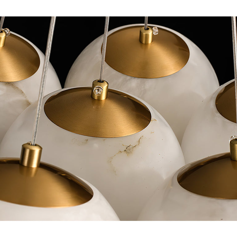 Close-up of alabaster globe shades with brass-colored caps and visible stone veining