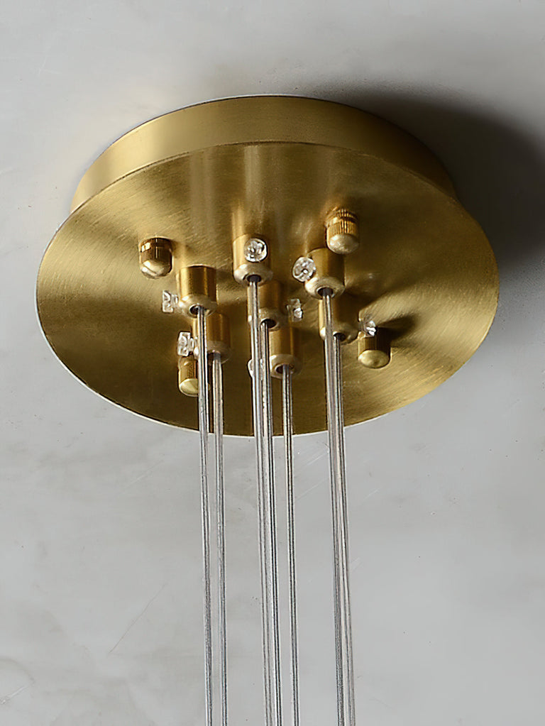 Close-up of the brass-colored ceiling canopy and suspension wire fittings