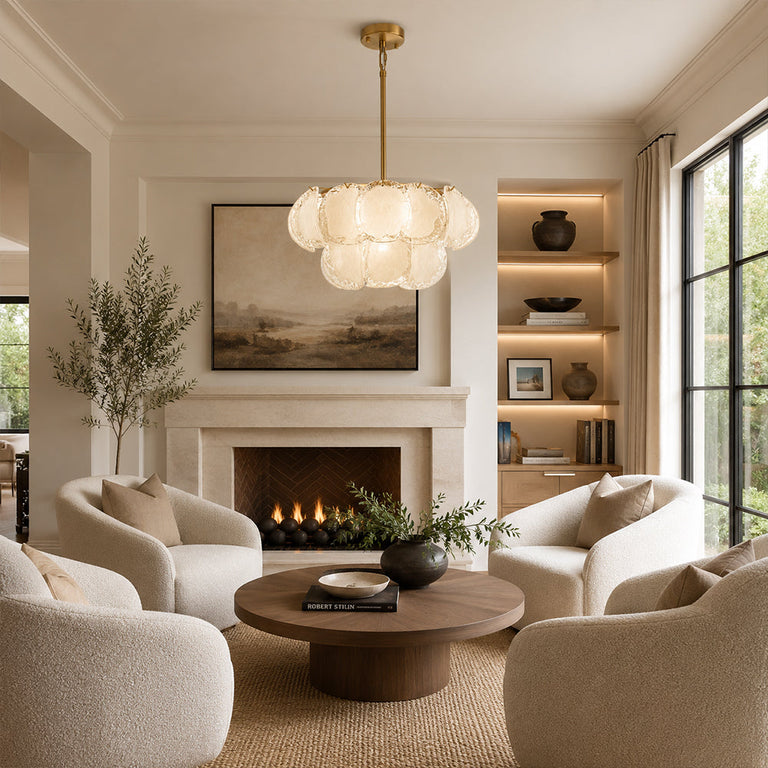Two-tier petal glass chandelier above rounded armchairs facing a plaster fireplace.