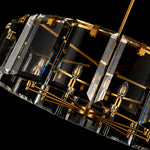 Angled close-up of a brass-tone drum frame and clear crystal bars.
