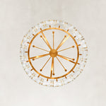 Underside view of a round brass-tone chandelier framework and clear crystal bars.