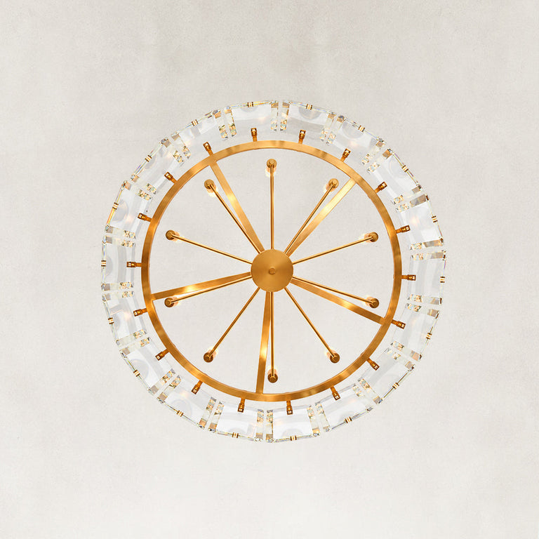 Underside view of a round brass-tone chandelier framework and clear crystal bars.