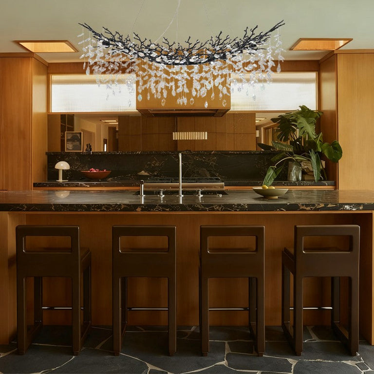Black branch chandelier above a kitchen island.