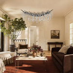 Black branch chandelier in a living room with sofas.