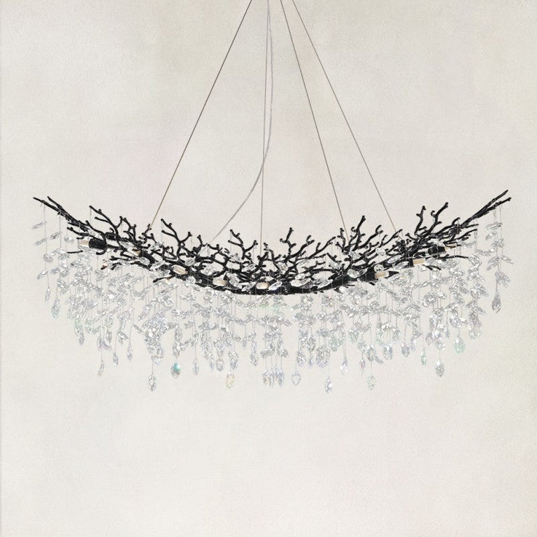 Unlit linear branch chandelier with black framework and hanging clear crystals.