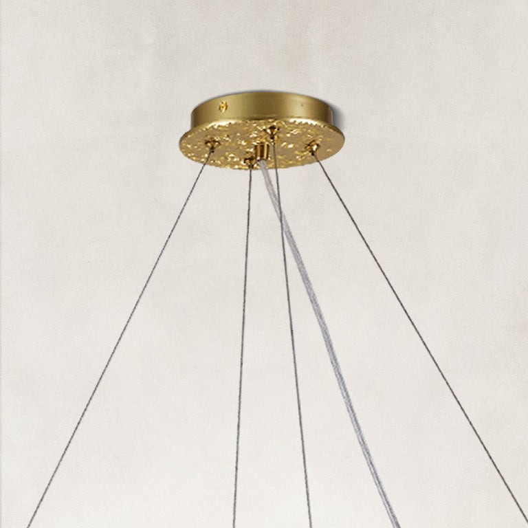 Brass-tone round chandelier canopy and suspension-wire detail.