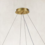 Brass-tone chandelier canopy and suspension cable detail.