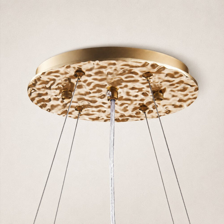 Round gold-tone ceiling canopy and suspension cables.