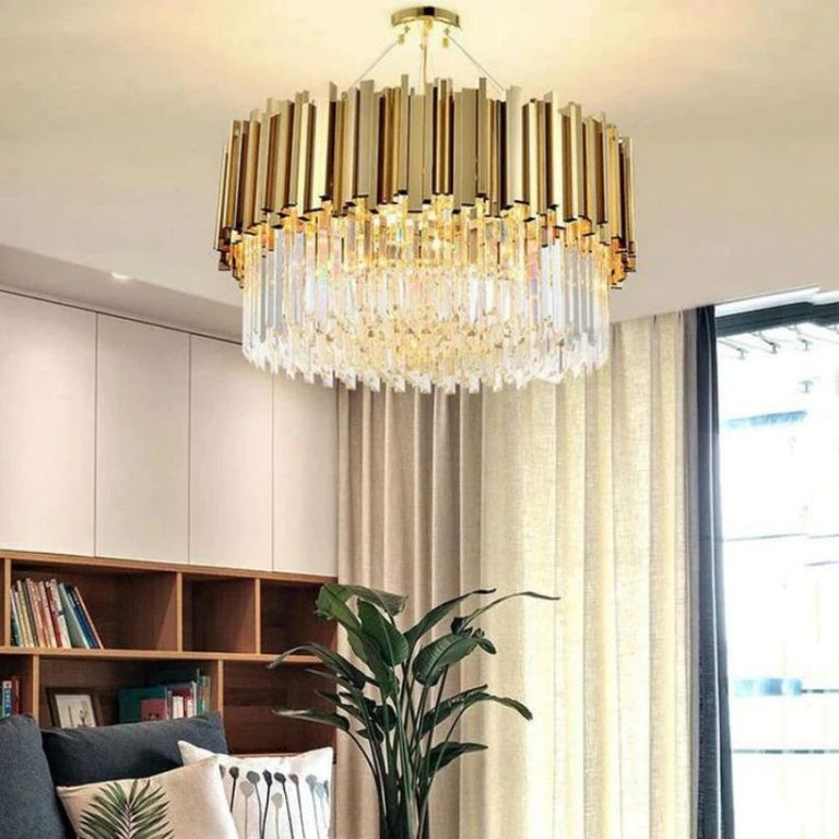 Gold-tone crystal drum chandelier beside a window and a bookcase.