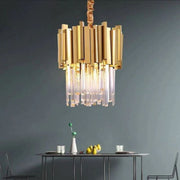 Single illuminated crystal crown pendant above a table against a dark wall.