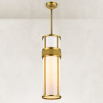 Cylindrical pendant with a white acrylic diffuser, gold-tone frame and single suspension rod.