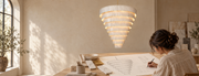Designer sketching a tiered marble chandelier beside stone and brass samples