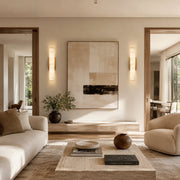 Alabaster Column Wall Sconce, 20 in in Brass beside wall art in a living room
