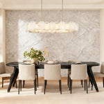 Brass alabaster petal oval chandelier illuminated above a dining table