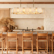 Brass alabaster petal oval chandelier illuminated above a kitchen island