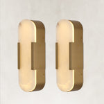 Two brass alabaster pill wall sconces shown from the side
