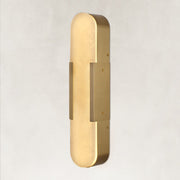 Brass alabaster pill wall sconce illuminated in an angled view