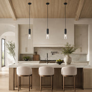 Three black ribbed glass pendant lights above a warm neutral kitchen island