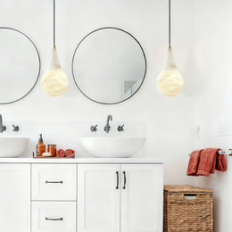 Teardrop Alabaster Pendant, 7.1 in in Brass over bathroom basins