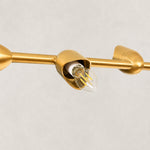 Linear disc chandelier, exposed bulb inside a gold-tone shade holder.
