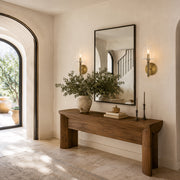 Aged brass embossed bubble glass wall sconces flanking an entryway mirror