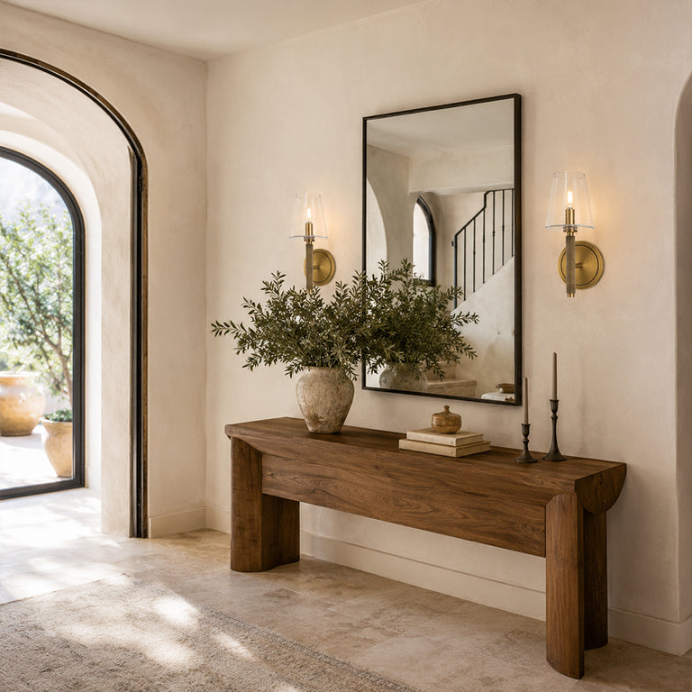 Aged brass embossed bubble glass wall sconces flanking an entryway mirror