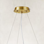 Gold-colored chandelier canopy and suspension cables.