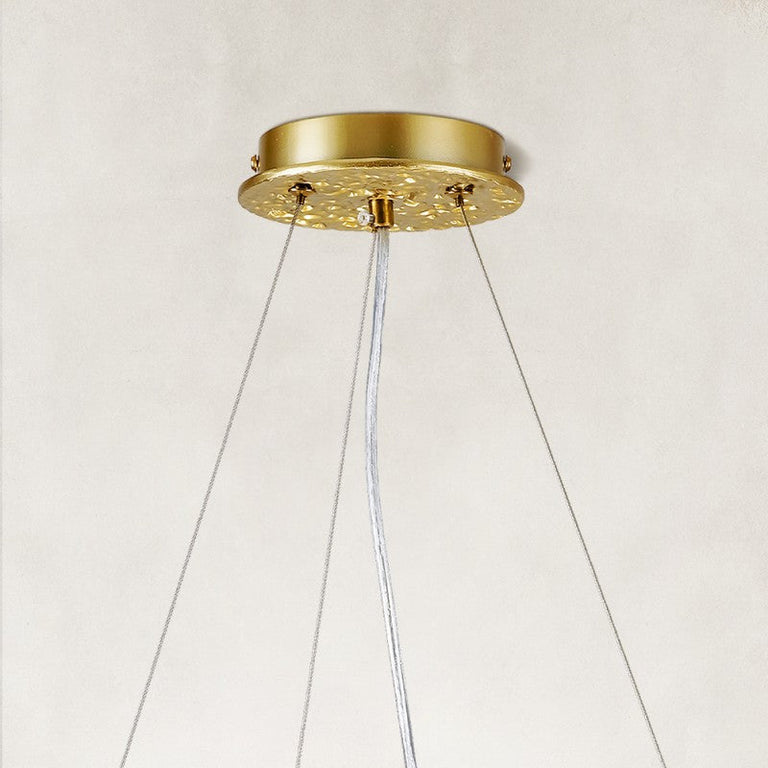 Gold-colored chandelier canopy and suspension cables.