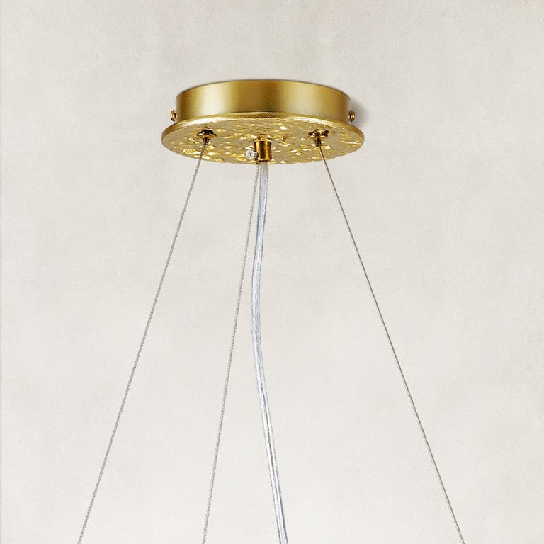 Gold-colored chandelier canopy and suspension cables.