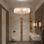 Layered alabaster ring chandelier with gold-tone canopy in a bathroom.