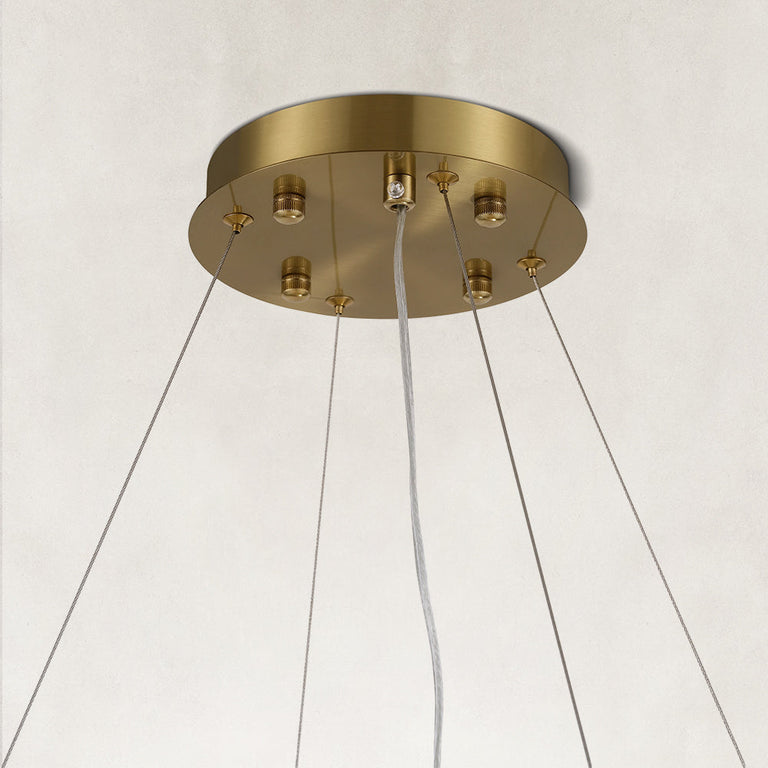 Gold-tone canopy and suspension cables of a layered ring chandelier.