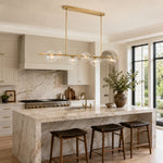 Gold-tone bubble glass chandelier above a marble kitchen island in an interior setting