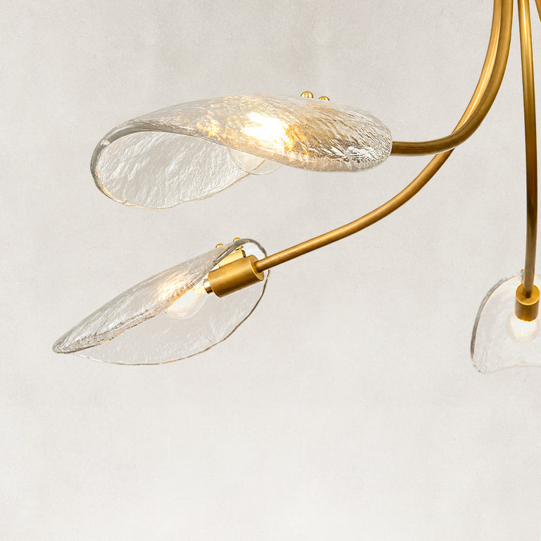 Gold-tone chandelier illuminated glass leaves close view